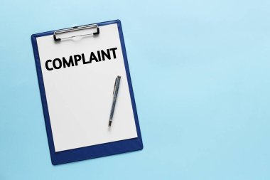 Açık mavi arkaplandaki panoya eklenmiş kelime şikayetleri olan kağıt, üst görünüm. Metin için boşluk