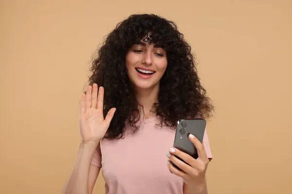 Ευτυχισμένη Νεαρή Γυναίκα Κοιτάζοντας Smartphone Και Χαιρετώντας Γεια Μπεζ Φόντο — Φωτογραφία Αρχείου