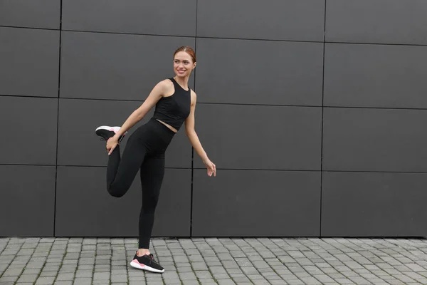 Schöne Frau Turnbekleidung Macht Übungen Der Nähe Der Dunkelgrauen Wand — Stockfoto