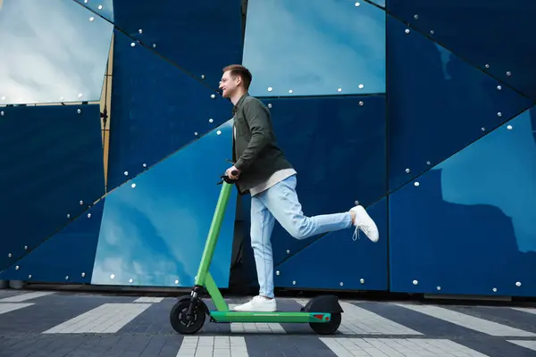 快乐的男人骑着现代电动车在城市街道上 — 图库照片