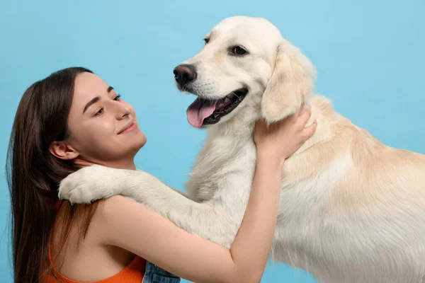 快乐的女人和可爱的拉布拉多猎犬在浅蓝色的背景下 可爱的宠物 — 图库照片