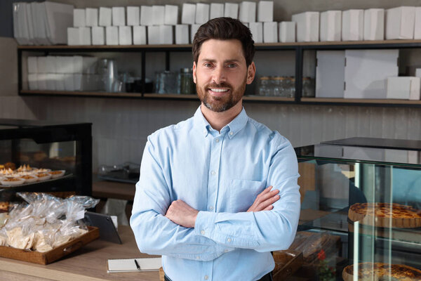 Portrait of happy business owner in bakery shop
