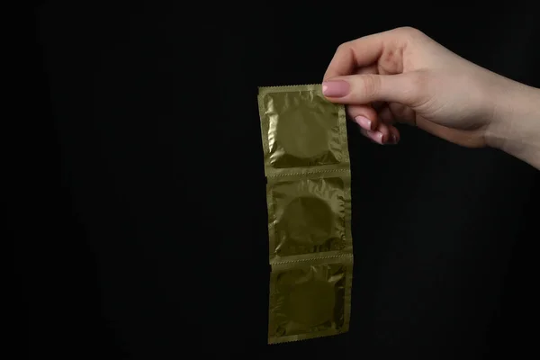 Žena Drží Kondomy Černém Pozadí Detailní Záběr Mezera Pro Text — Stock fotografie