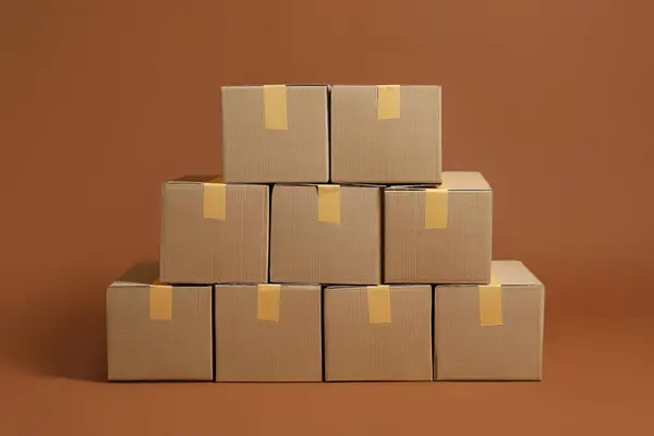 Stack of many cardboard boxes on brown background