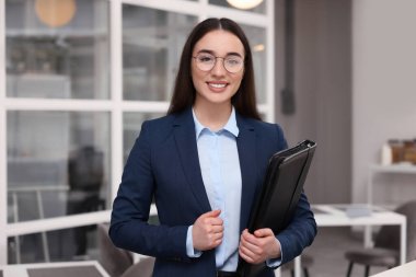 Ofisinde deri portföyü olan mutlu bir emlakçı.