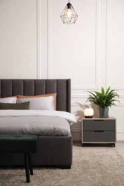 Şık bir yatak odası, geniş rahat bir yatak ve şilte.