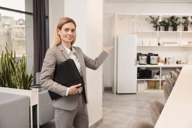 İçeride deri portföyü olan mutlu bir emlakçı.