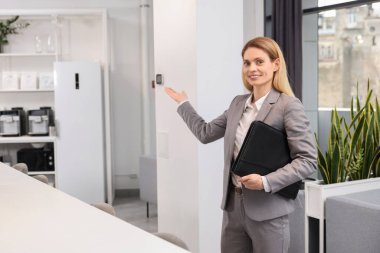 İçeride deri portföyü olan mutlu bir emlakçı.