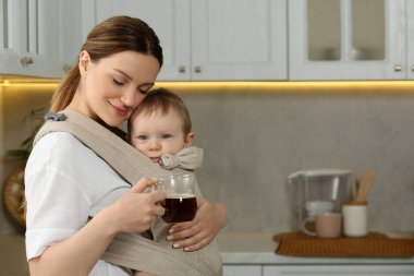 Anne bir bardak içkiyle çocuğunu mutfaktaki askıda tutuyor.