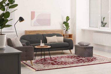 Şık mobilyaları ve güzel desenli yumuşak halısı olan rahat bir oda.
