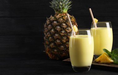 Lezzetli ananas püresi ve siyah masada meyve. Metin için boşluk