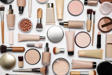 Beyaz arka planda yüz pudraları ve diğer makyaj ürünleri, düz yatıyordu