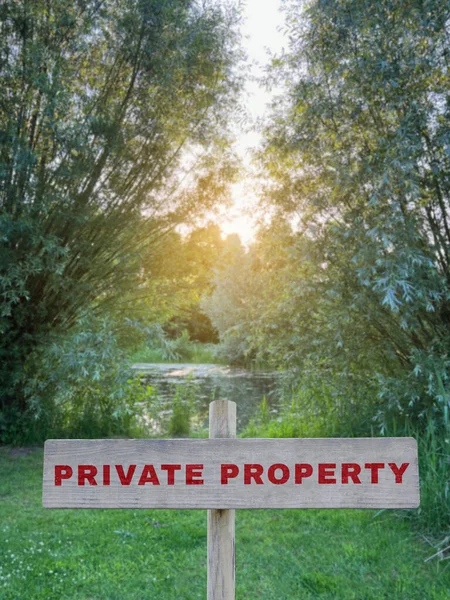 Wooden sign with text Private Property near lake