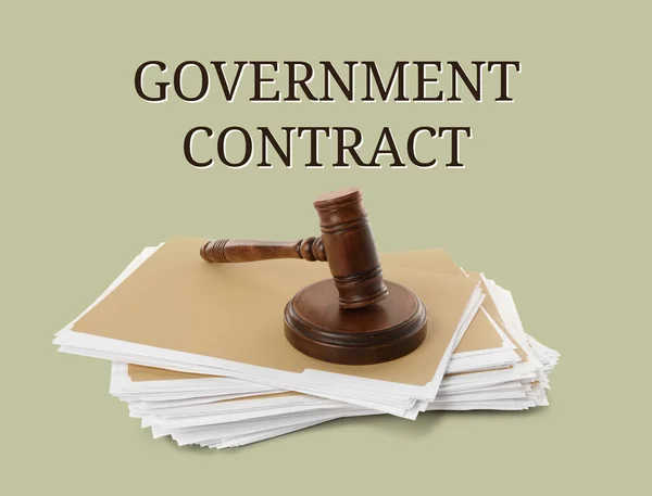 Words Government Contract, wooden gavel and file folders with documents on light background