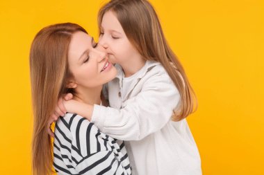 Turuncu arka planda anne ve tatlı kızının portresi.