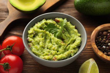 Lezzetli guacamole ve ahşap masadaki malzemeler
