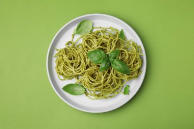 Pesto soslu lezzetli makarna ve açık yeşil arka planda fesleğen.