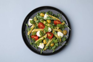 Açık gri masada nefis pesto makarna salatası, üst manzara.