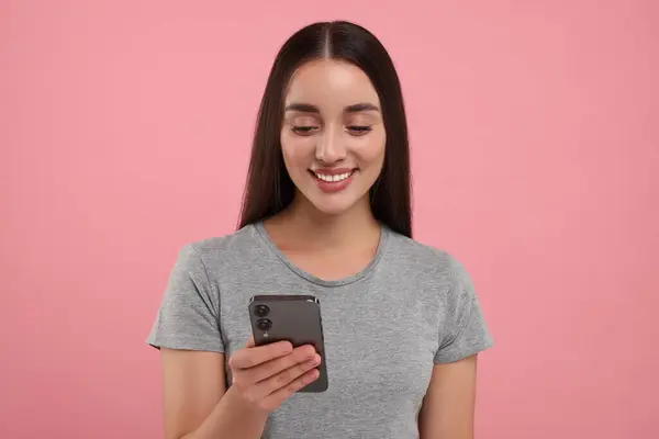 Jovem Feliz Olhando Para Smartphone Fundo Rosa — Fotografia de Stock
