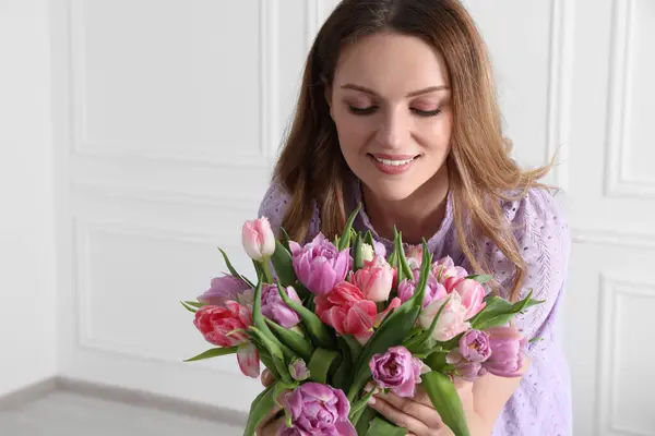 屋内で美しいチューリップの花束を持つ若い女性 テキスト用スペース — ストック写真