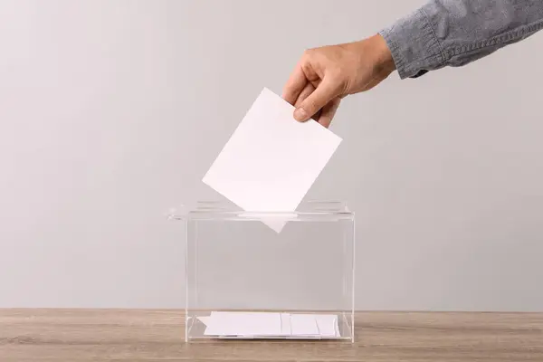 Mann Legt Seine Stimme Die Wahlurne Auf Hellgrauem Hintergrund Nahaufnahme — Stockfoto