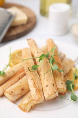Tabakta fırında salata kökü ve limon var, yakın plan.