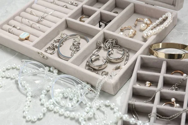 浅灰桌子上有许多不同配件的珠宝盒 — 图库照片