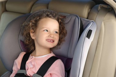 Arabadaki çocuk emniyet koltuğunda oturan tatlı küçük kız.