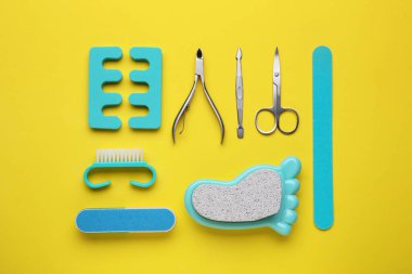 Sarı arkaplan üzerinde pedikür araçları kümesi, düz yatar