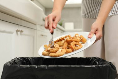 Kadın içeri soğan halkaları atıyor, yakın plan.