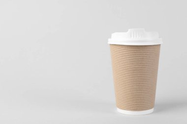 Arka planda plastik kapaklı kağıt bardak, metin için boşluk. Kahve hazır.