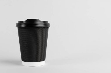Arka planda plastik kapaklı siyah kağıt bardak, metin için boşluk. Kahve hazır.