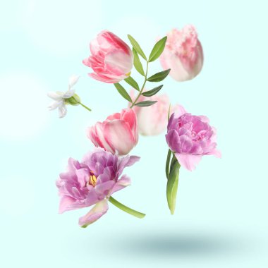 Güzel çiçekler ve yeşil yapraklar pastel turkuaz arka plana dökülüyor.