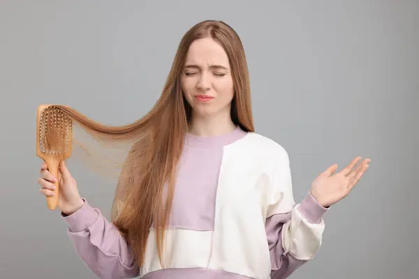 Συναισθηματική Γυναίκα Βουρτσίζει Μαλλιά Της Ανοιχτό Γκρι Φόντο Αλωπεκία Πρόβλημα — Φωτογραφία Αρχείου
