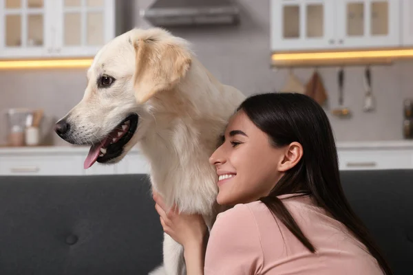 自宅でソファーでラブラドールレトリーバー犬を愛する幸せな女性 愛らしいペット — ストック写真