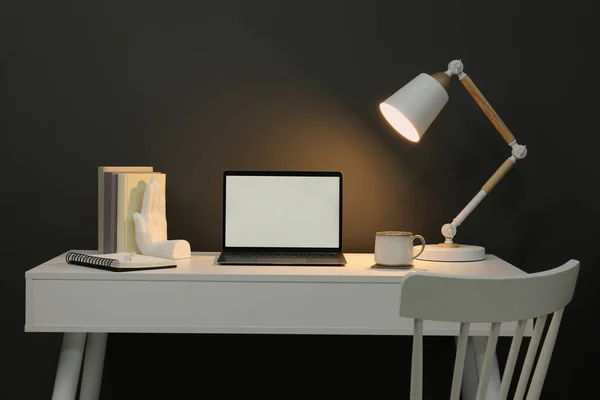 Gri Duvarın Yanındaki Beyaz Masada Dizüstü Bilgisayarı Lambası Fincanı Dekoru — Stok fotoğraf