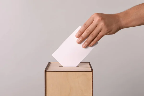 Homem Colocando Seu Voto Urna Fundo Cinza Claro Close — Fotografia de Stock