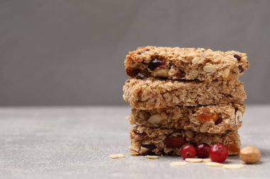 Açık gri masadaki leziz granola çubukları, yakın plan. Metin için boşluk