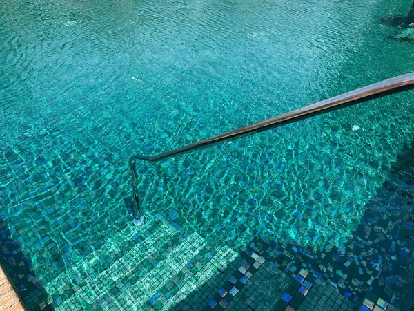 Metal rail and steps in outdoor swimming pool