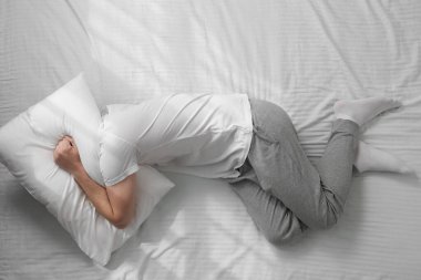 Yatakta uykusuzluk çeken bir adam.