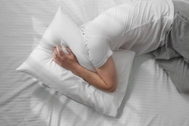 Yatakta uykusuzluk çeken bir adam.