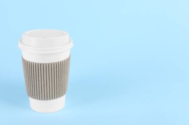 Açık mavi arka planda plastik kapaklı kağıt bardak, metin için boşluk. Kahve hazır.