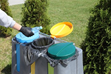 Dışarıdaki çöp kutusuna plastik şişe atan kadın, yakın plan. Geri dönüşüm kavramı