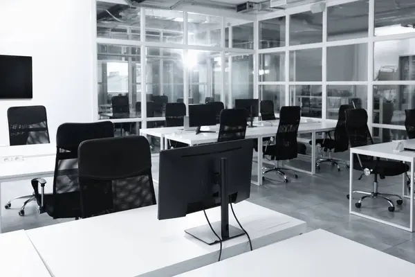 Stylish interior of open plan office. Workspace with computers, tables and chairs