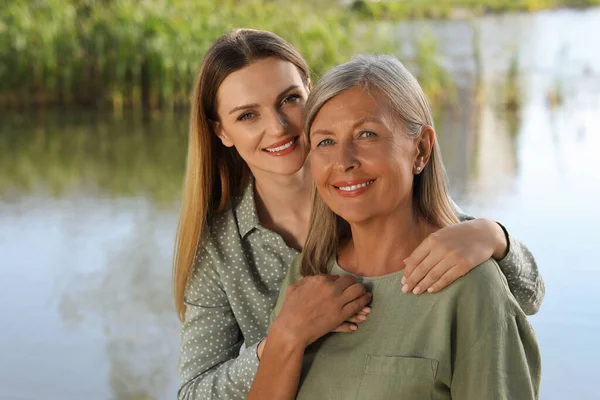 stock image Family portrait of happy mother and daughter spending time together near pond