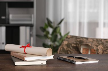 Diploma, defter ve kalem kapalı bir masa üzerinde. Askeri eğitim