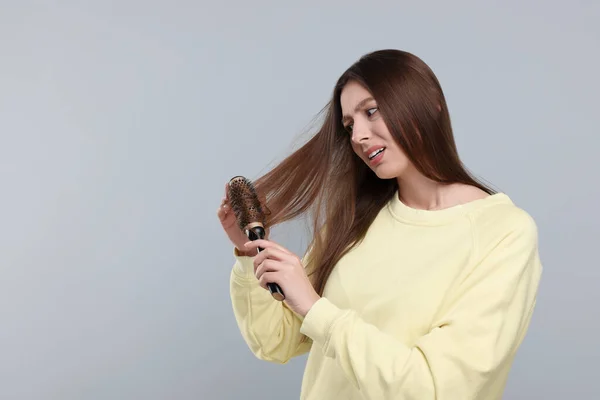 Αναστατωμένη Γυναίκα Βουρτσίζει Μαλλιά Της Γκρι Φόντο Χώρος Για Κείμενο — Φωτογραφία Αρχείου