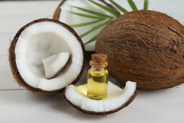 Butelka Organicznego Oleju Kokosowego Liści Świeżych Owoców Białym Drewnianym Stole — Zdjęcie stockowe