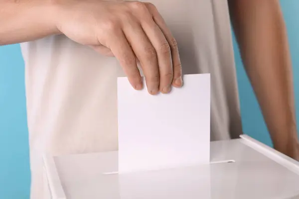 Άνθρωπος Βάζει Την Ψήφο Του Στην Κάλπη Ανοιχτό Μπλε Φόντο — Φωτογραφία Αρχείου