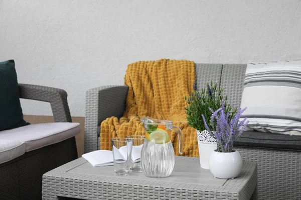Tisch Mit Buch Wasserkrug Topfpflanzen Und Sofas Auf Der Außenterrasse — Stockfoto